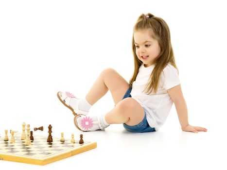 A little girl is playing chess. The concept of creative education of a child, training of thinking. Isolated on white background