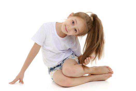 Beautiful little girl kneels in the studio on a white background. The concept of beauty and fashion, children's emotions. Isolated.