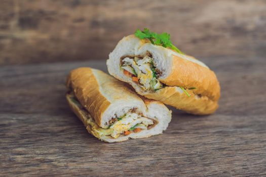 A delicious Vietnamese Bahn Mi sandwich on a wooden background.