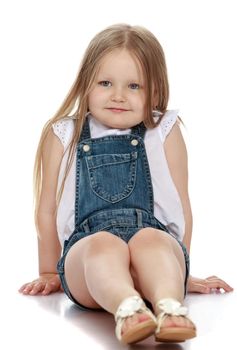 Beautiful little girl with long blonde hair below the belt is sitting on the floor - Isolated on white background