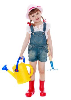 Cute little girl in pink hat and red boots . The girl is holding a watering can and rake-Isolated on white background