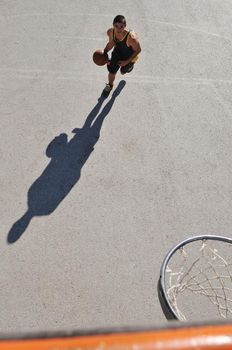 gorup of young boys who playing basketball outdoor on street with long shadows and bird view perspective