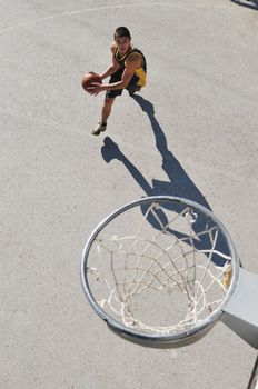 gorup of young boys who playing basketball outdoor on street with long shadows and bird view perspective