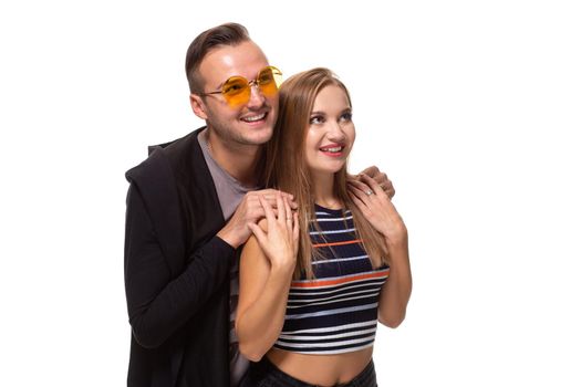 Happy young lovely couple standing together and laughing. Studio shot over white background. Friendship, love and relationships concept