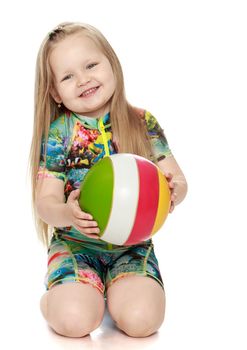 Happy little girl sitting on floor and holding a ball - Isolated on white background