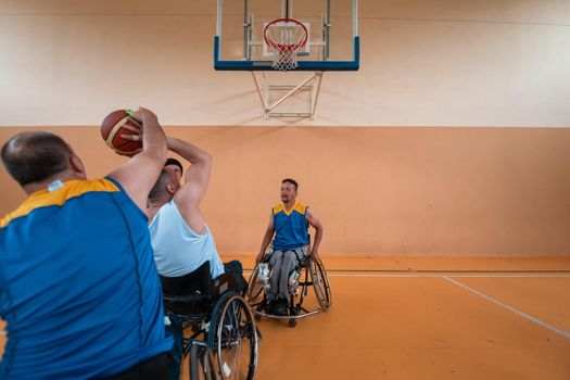 Disabled War or work veterans mixed race and age basketball teams in wheelchairs playing a training match in a sports gym hall. Handicapped people rehabilitation and inclusion concept.Hi quality photo