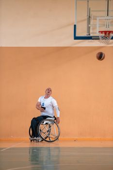 disabled war veterans in action while playing basketball on a basketball court with professional sports equipment for the disabled. High quality photo. Selective focus 
