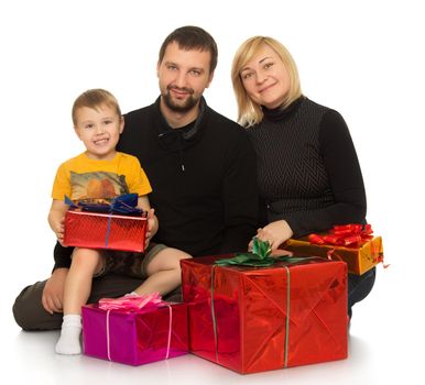 Happy family dad mom and their little son sitting on the floor surrounded by gifts - Isolated on white background