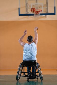 a war invalid in a wheelchair train with a ball at a basketball club in training with professional sports equipment for the disabled. the concept of sport for people with disabilities. High quality photo