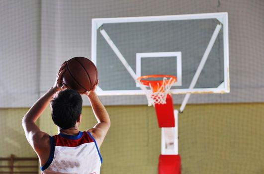 young healthy man play basketball game indoor in gym