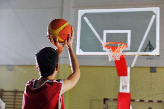 young healthy man play basketball game indoor in gym