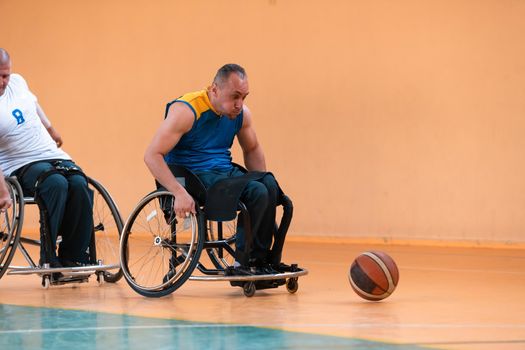 disabled war veterans in action while playing basketball on a basketball court with professional sports equipment for the disabled. High quality photo. Selective focus 