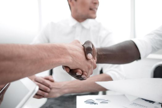 close up.handshake business partners sitting at the Desk.business concept