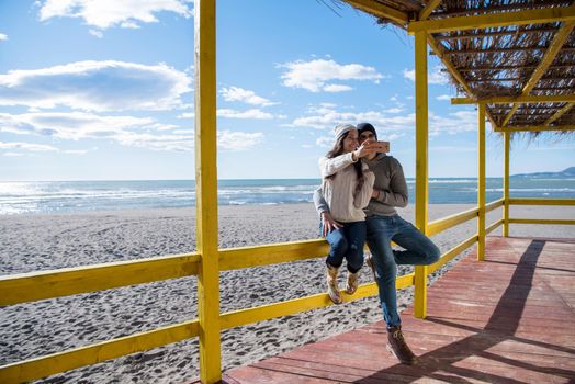 Very Happy Couple In Love Taking Selfie On The Beach in autmun day