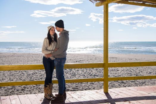 Happy couple enyojing time together on beach during autumn day