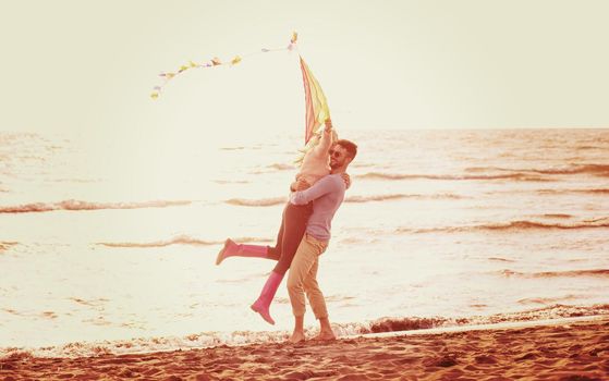 Young Couple having fun and Playing With A Kite On The Beach at autumn day filter