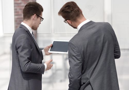 two businessmen reading a message on a digital tablet . photo with text space