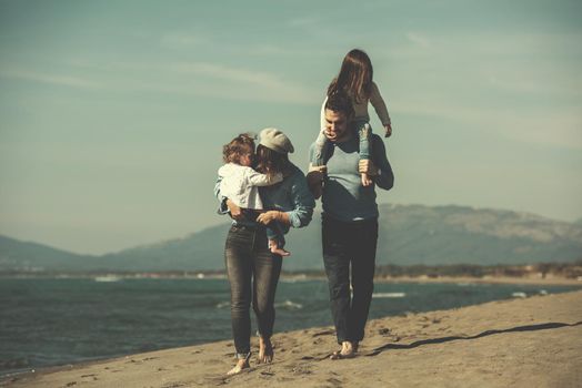 Family with kids resting and having fun at beach during autumn day filter