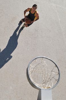 gorup of young boys who playing basketball outdoor on street with long shadows and bird view perspective