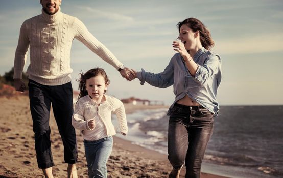 Family with kids resting and having fun at beach during autumn day filter