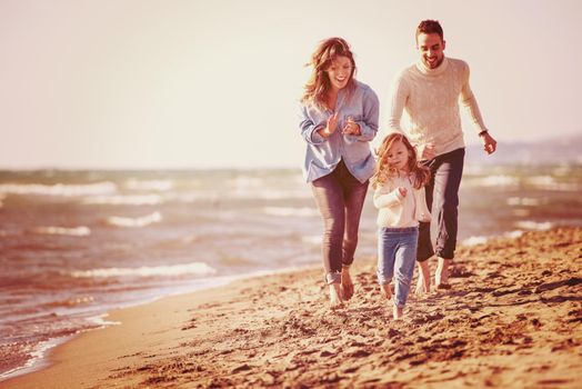 Family with kids resting and having fun at beach during autumn day filter