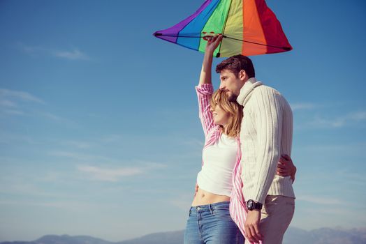 Young Couple having fun and Playing With A Kite On The Beach at autumn day filter