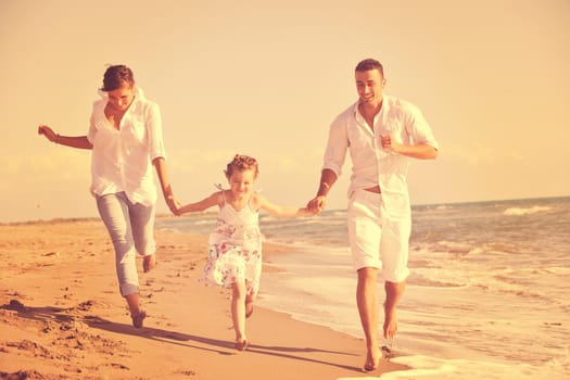 happy young family in white clothing have fun at vacations on beautiful beach 