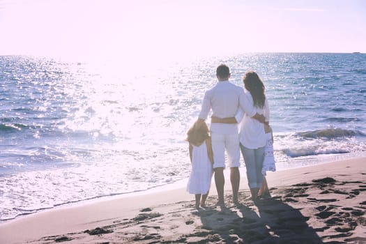 happy young family in white clothing have fun at vacations on beautiful beach 