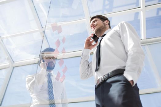 bottom view.businessman talking on mobile in the office.business concept