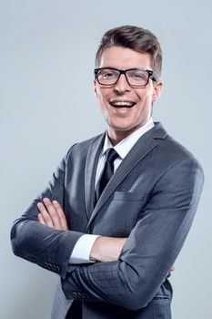 Serious young casual man in siute with crossed arms looking at camera. Full body length portrait isolated over gray background.