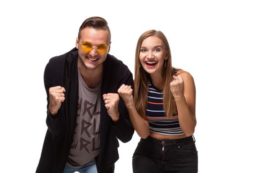 Overjoyed woman and man raise fists with triumph, have successful deal, exclaim joyfully, isolated over white background. People, collaboration and success concept. Hooray, we did it finally