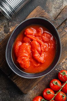 Peeled tomatoe, on old dark rustic background, top view flat lay