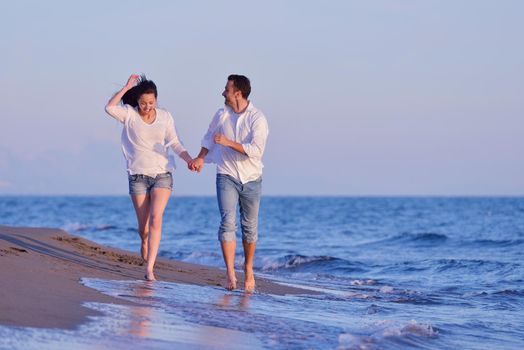 happy young romantic couple in love have fun on beautiful beach at beautiful summer day