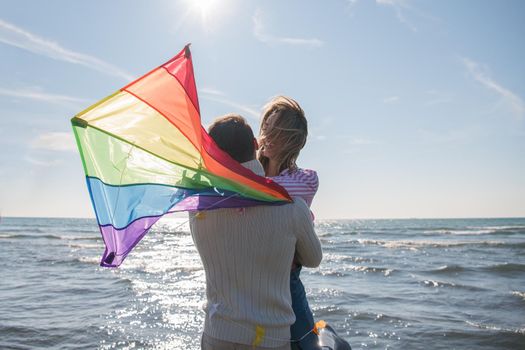 Young Couple having fun and Playing With A Kite On The Beach at autumn day