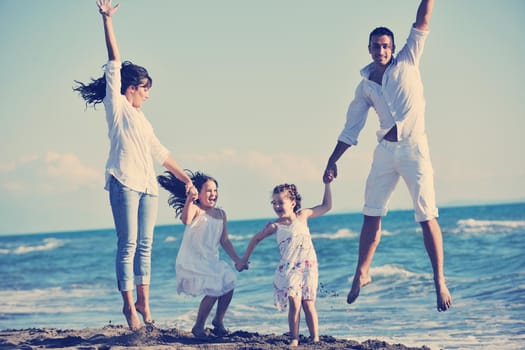 happy young family in white clothing have fun at vacations on beautiful beach 