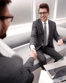 close up. smiling business partners shaking hands with each other.concept of partnership