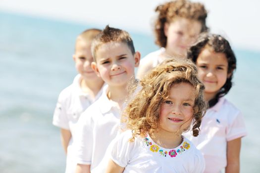 group of happy child on beach who have fun and play games