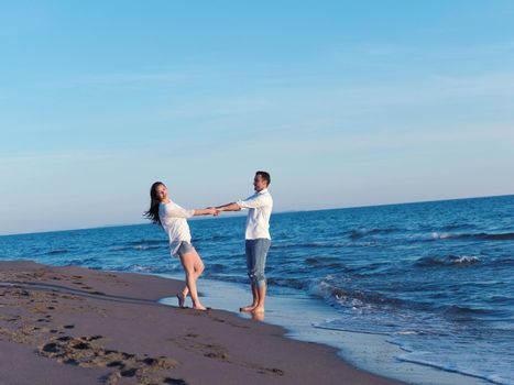 happy young romantic couple in love have fun on beautiful beach at beautiful summer day