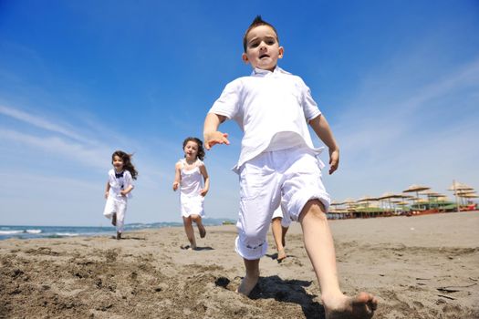 group of happy child on beach who have fun and play games