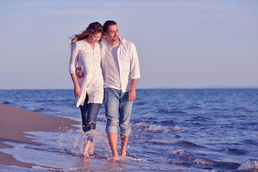 happy young romantic couple in love have fun on beautiful beach at beautiful summer day