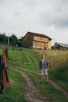 The guy in a shirt and shorts on the side of the hill, enjoying nature.