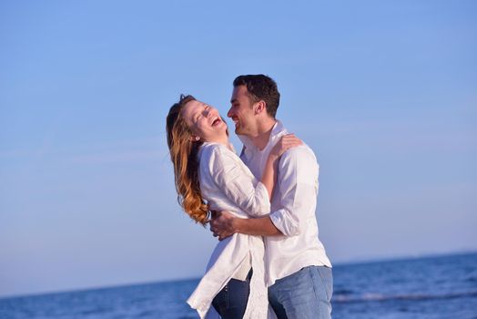 happy young romantic couple in love have fun on beautiful beach at beautiful summer day