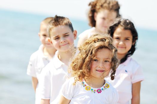 group of happy child on beach who have fun and play games