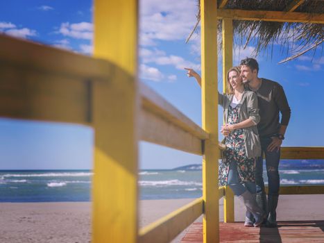 Happy couple enyojing time together on beach during autumn day colored filter