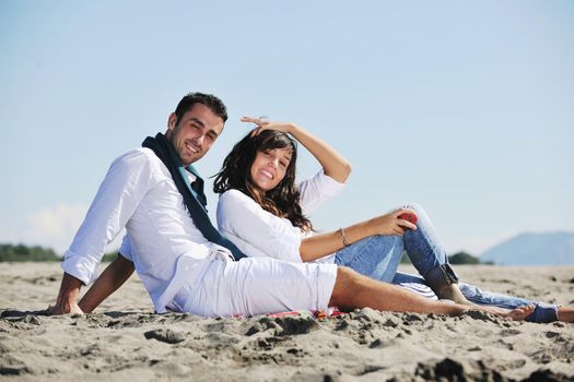 happy young couple enjoying  picnic on the beach and have good time on summer vacations