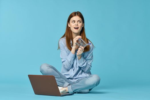 woman with laptop learning internet online education blue background. High quality photo