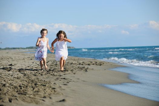 happy two little girls have fun and joy time at beautiful beach while running from joy 