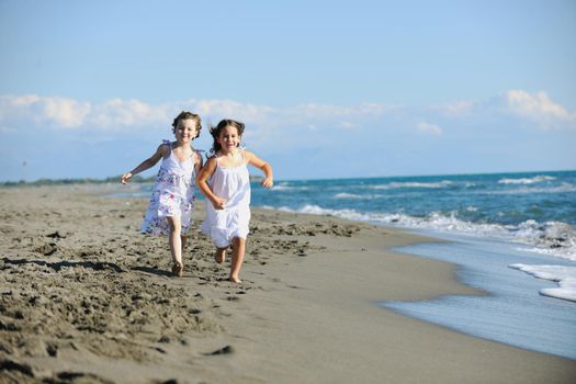 happy two little girls have fun and joy time at beautiful beach while running from joy 