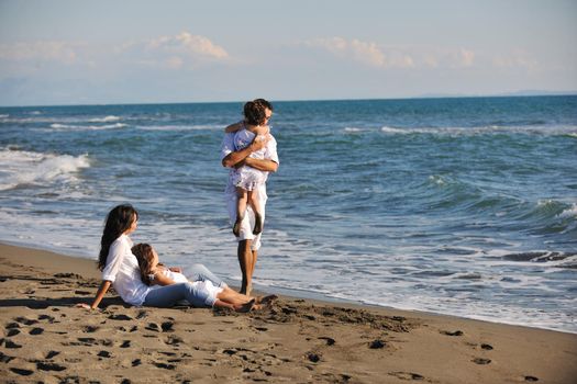 happy young family in white clothing have fun at vacations on beautiful beach 