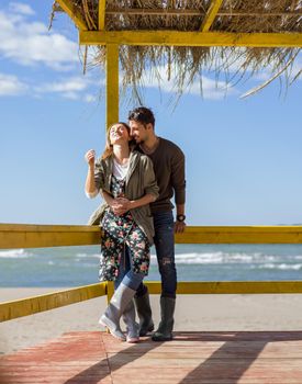 Happy couple enyojing time together on beach during autumn day